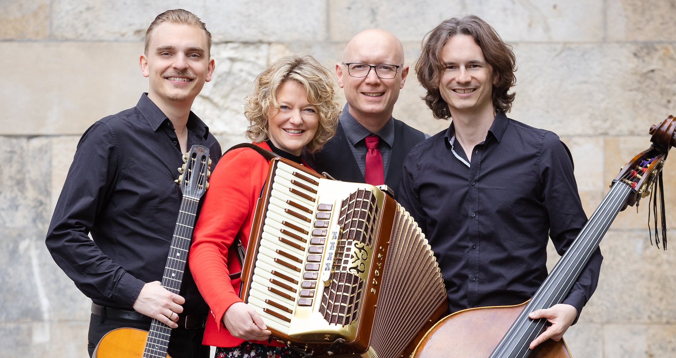 die vier Gruppenmitglieder mit Instrumenten