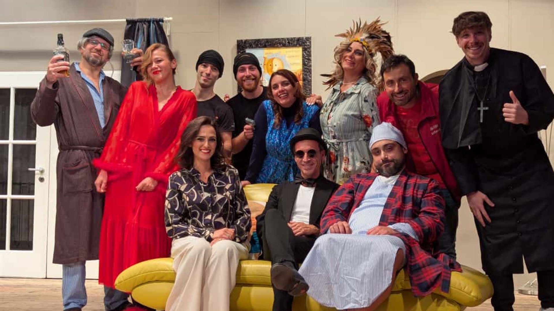 Foto für die Veranstaltung „Il morto è vivo“ mit allen Theaterfiguren sitzend auf einem gelben Sofa.