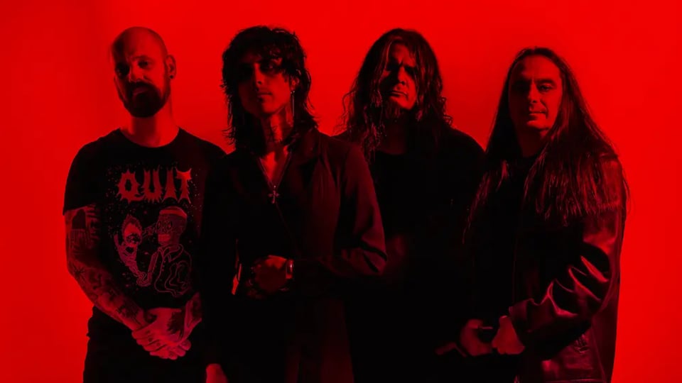 Vierköpfige Metalband in schwarzer Kleidung vor leuchtend rotem Hintergrund mit düsterer Konzertästhetik.