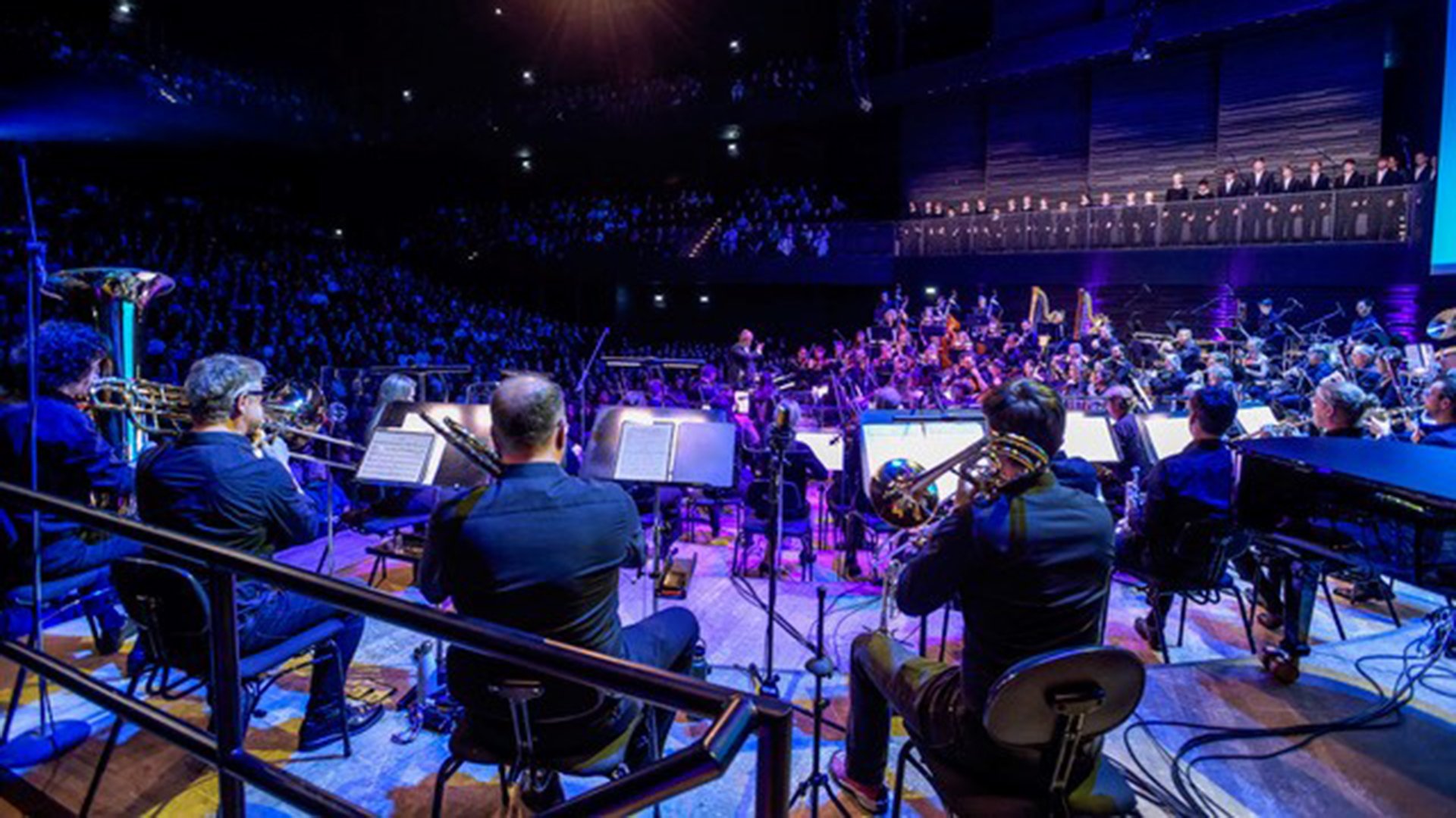 Ein Orchester mit Instrumenten von hinten auf der Bühne in blauem Licht, o, Hintergrund Publikum