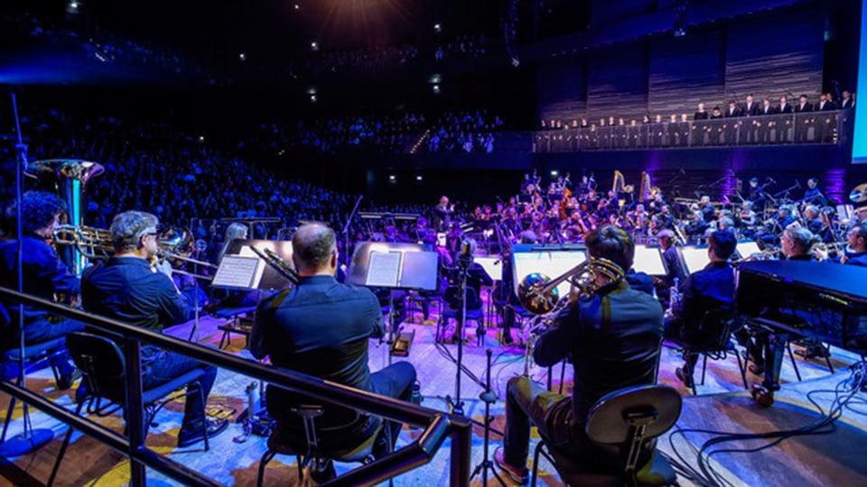 Ein Orchester mit Instrumenten von hinten auf der Bühne in blauem Licht, o, Hintergrund Publikum