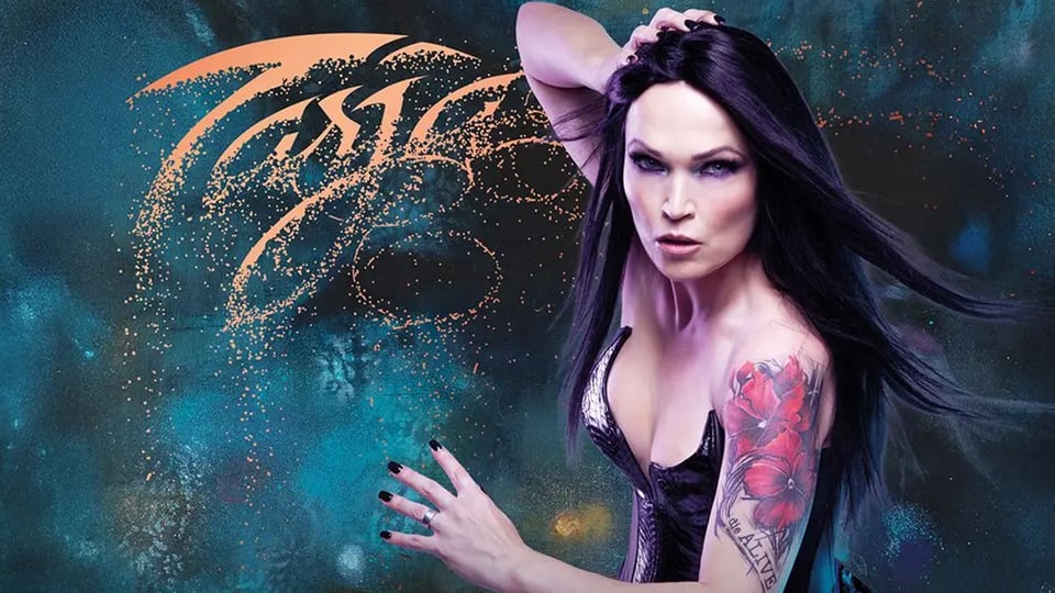 Die Künstlerin Tarja in einem ausgeschnittenen schwarzen Kleid mit einer Grafik ihres Namens auf verschwommenem petrolblauen Hintergrund