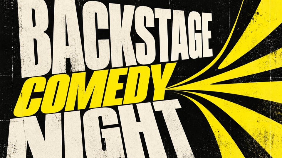 Plakat Backstage Comedy Night mit großem weiß gelbem Schriftzug auf schwarzem Hintergrund sowie gelben Strahlen, die von der rechten Bildseite zur Mitte verlaufen.