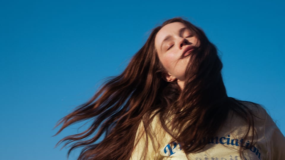 eine Dame mit langenhaaren vor blauem Hintergrund