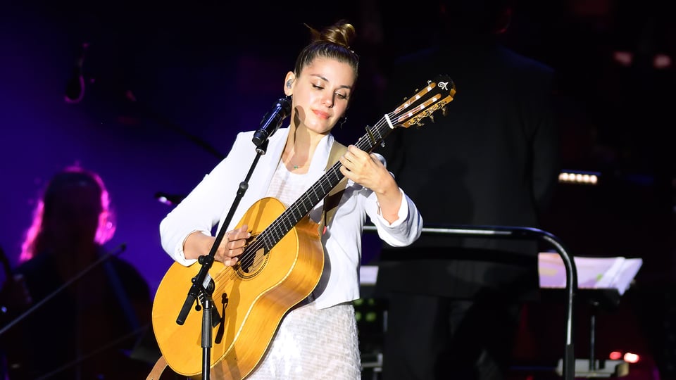 Foto von Katie Melua auf der Bühne mit Gitarre und Mikrofon