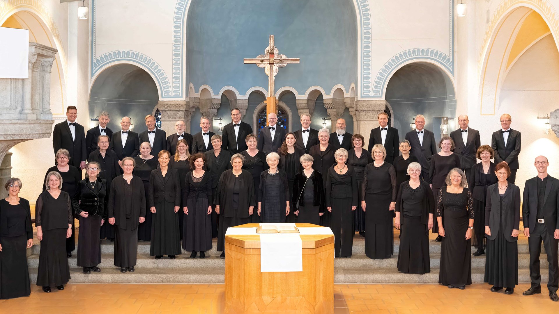 Die Mitglieder des Lassus Chor, schwarz gekleidet an einem Altar stehend