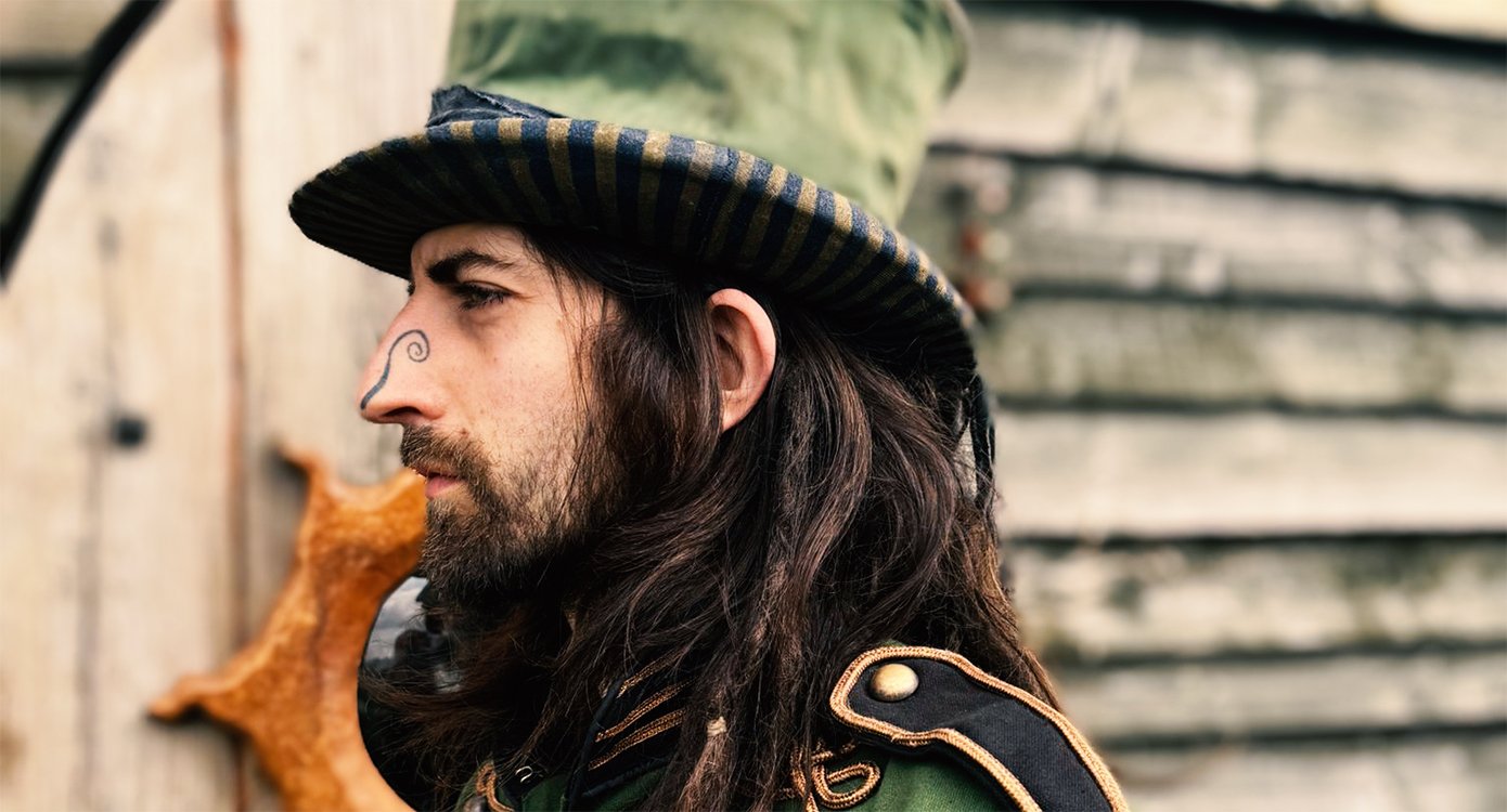 Foto von „CAM COLE“, verkleidet als Kobold, mit grünem Hut und bemalter Nase
