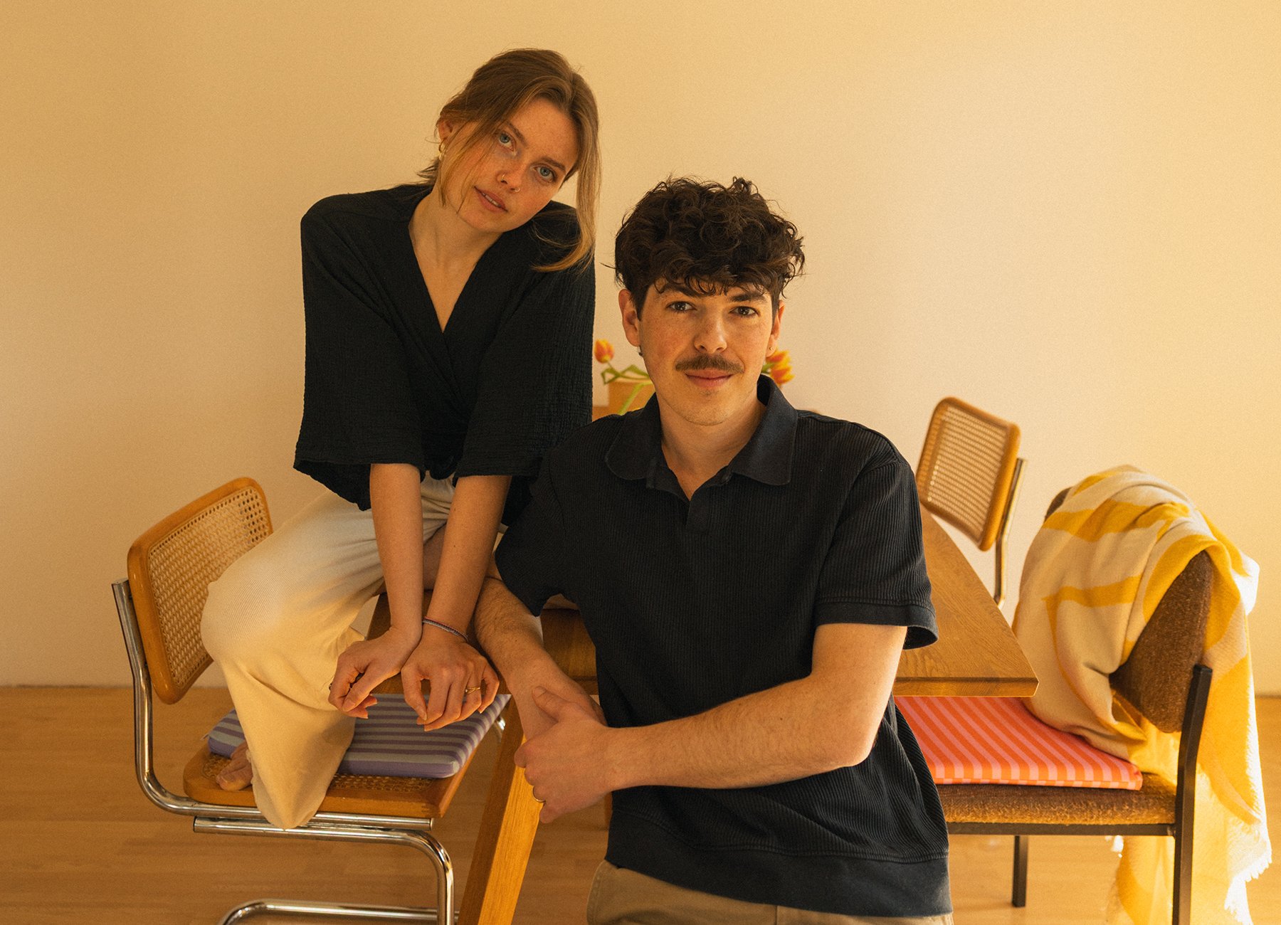 Foto von einem Jungen und einem Mädchen, die an einem Tisch sitzen. Das Foto hat gelbliche Farbtöne