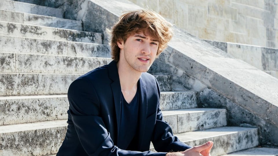 Ein Foto von einem Jungen, der auf einer Treppe sitzt.