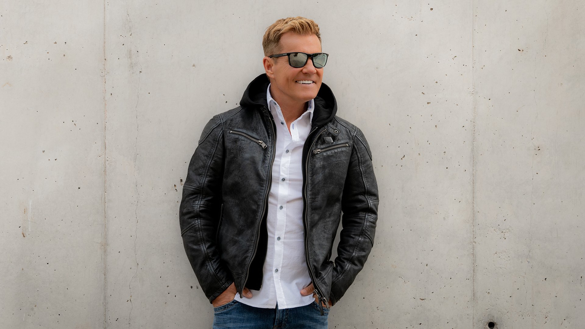 Dieter Bohlen, deutscher Musiker und Produzent, in einem Porträt mit Sonnenbrille, schwarzer Lederjacke und weißem Hemd vor heller Wand – Pressefoto zur „Cheri Cheri Lady Tour 2027“