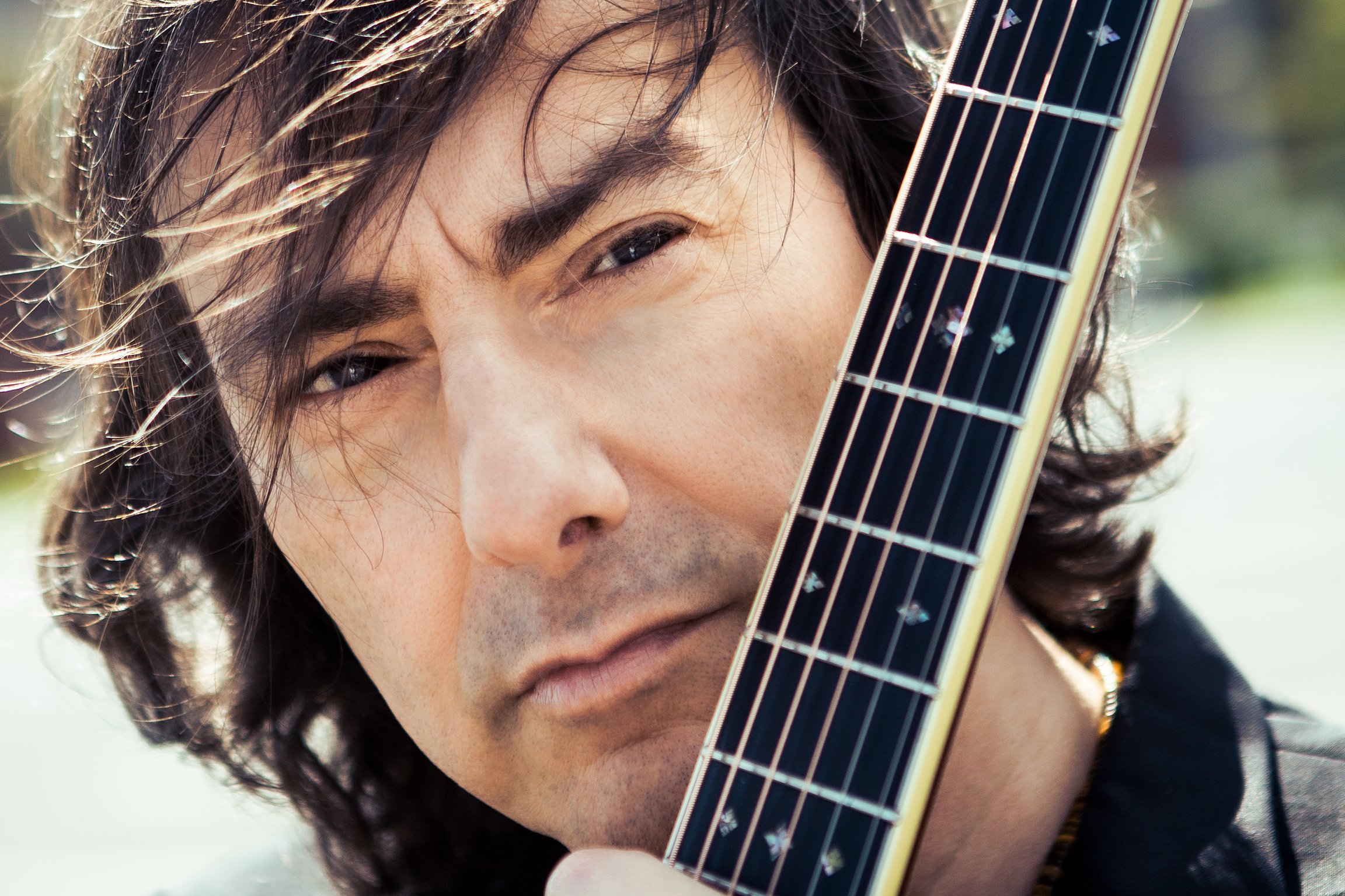 Portrait des Künstlers, auf dem auch der Gitarrenhals zu sehen ist