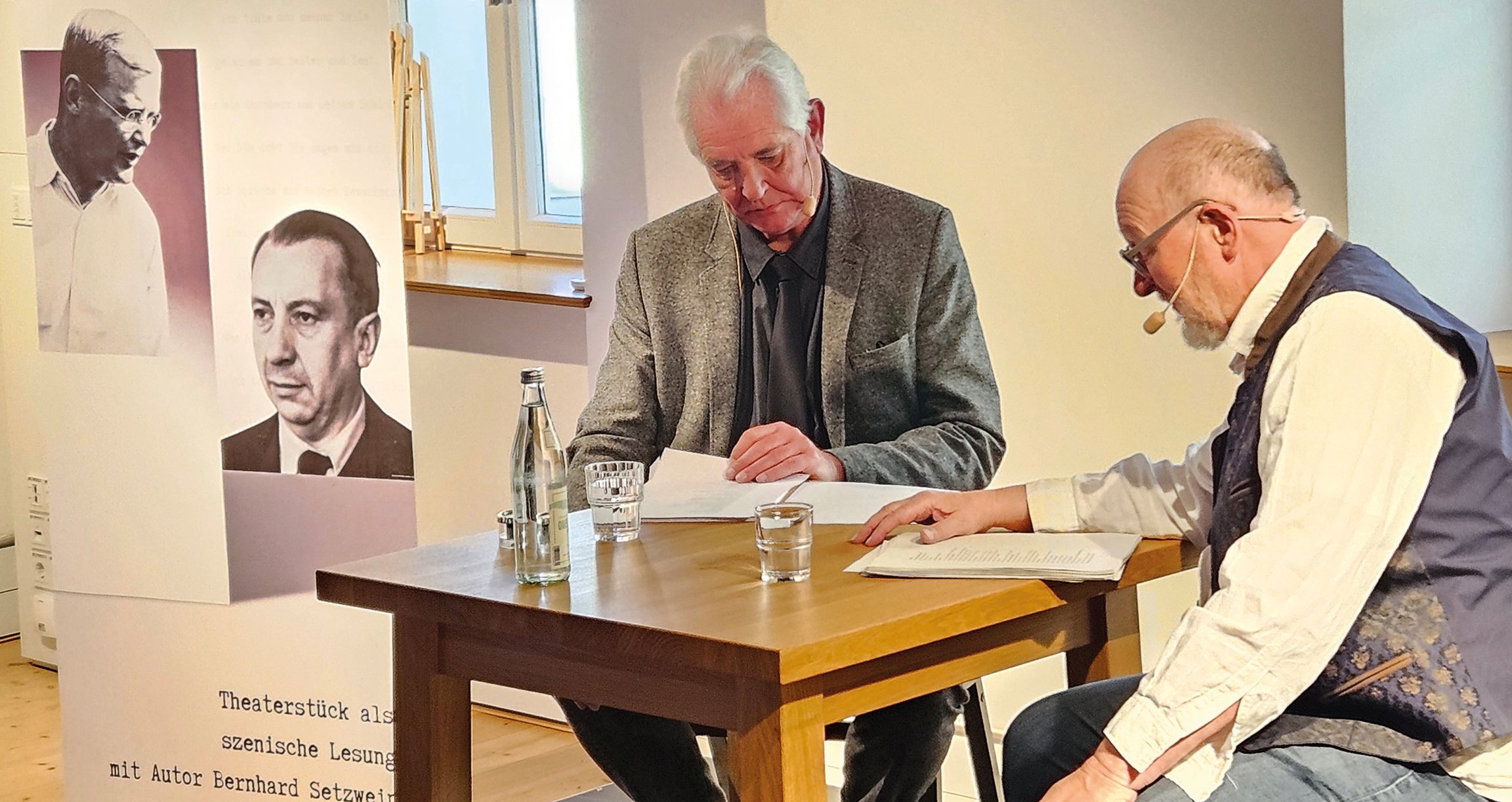 Foto von zwei Männern, die an einem Tisch sitzen und lesen