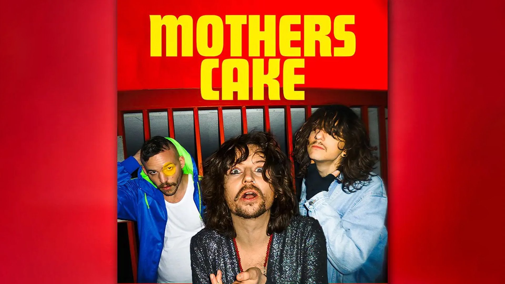 Bandfoto mit drei Personen vor rotem Hintergrund; oben der gelbe Schriftzug MOTHERS CAKE, die Personen stehen eng beieinander und blicken in die Kamera