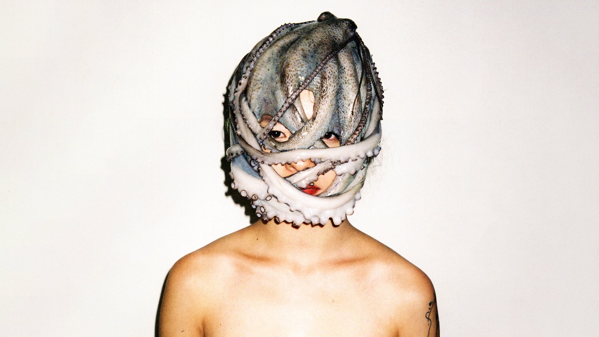 Foto für die Veranstaltung von Fischer Fritz mit einer Person mit einem Oktopus auf dem Kopf vor weißem Hintergrund.