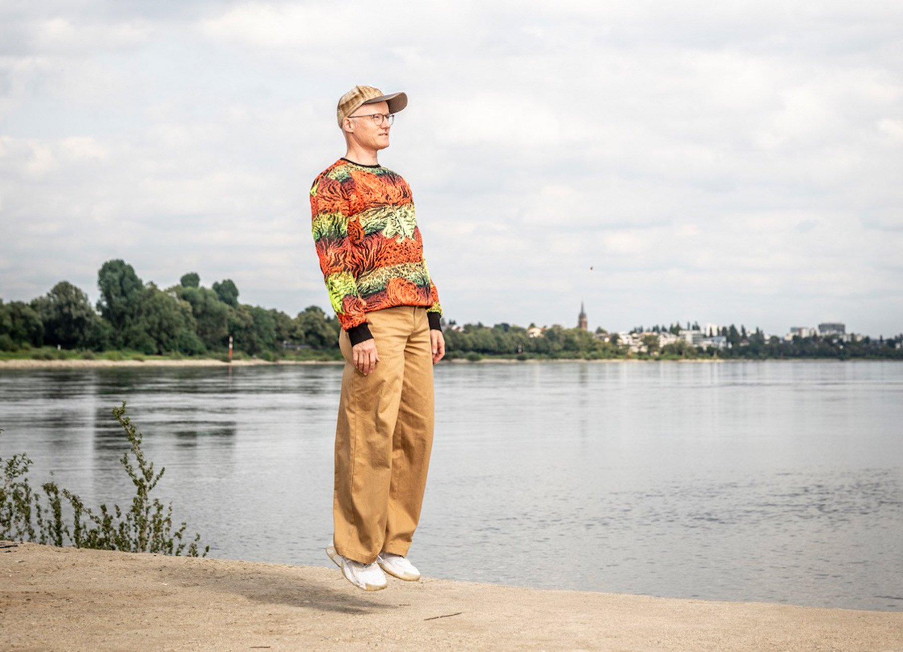 Foto eines Mannes, der schwebt, ohne den Boden zu berühren, mit einem See im Hintergrund.