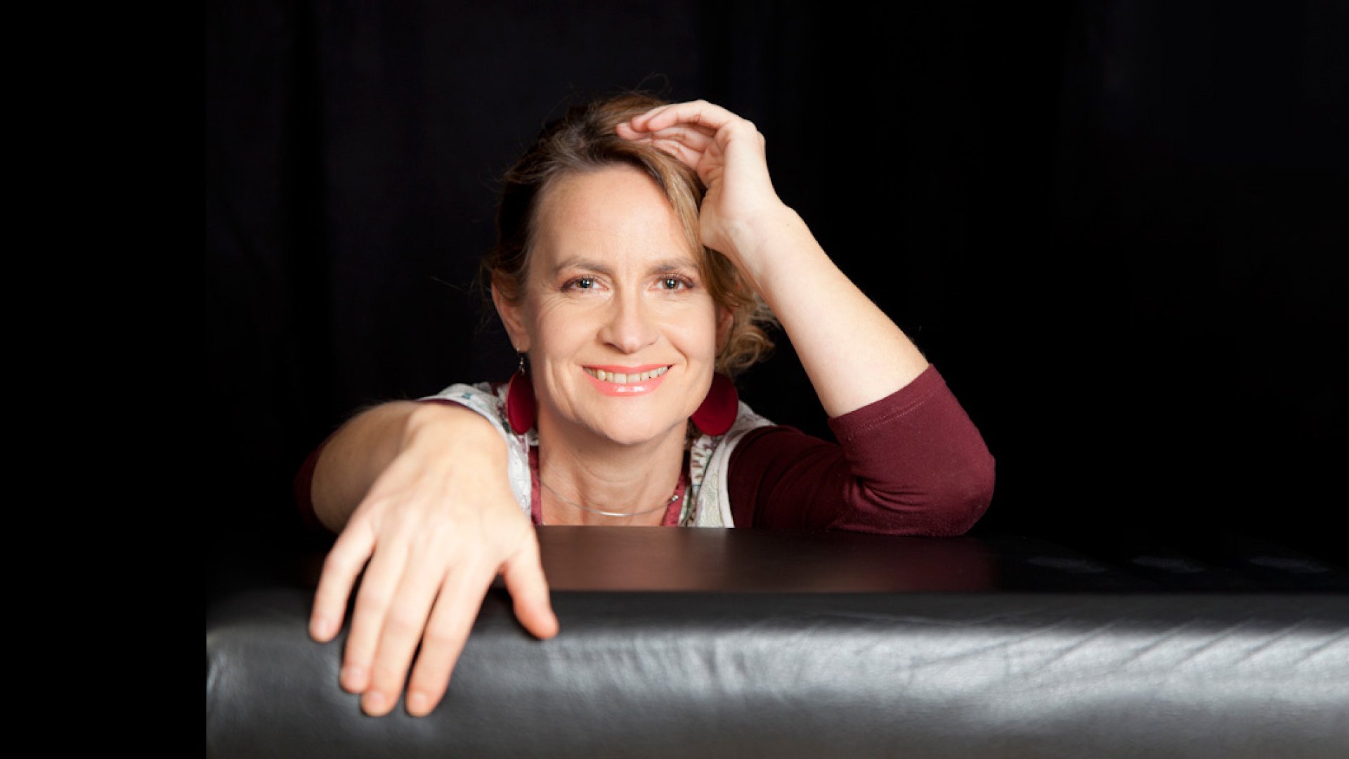 Foto für das Event von Nini Funke mit der Künstlerin vor schwarzem Hintergrund