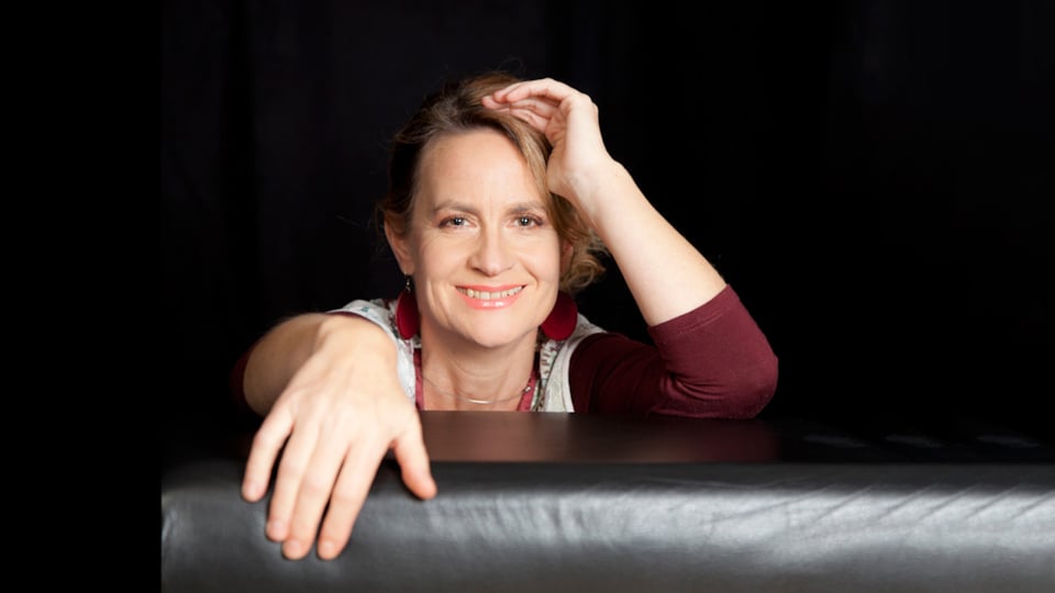 Foto für das Event von Nini Funke mit der Künstlerin vor schwarzem Hintergrund