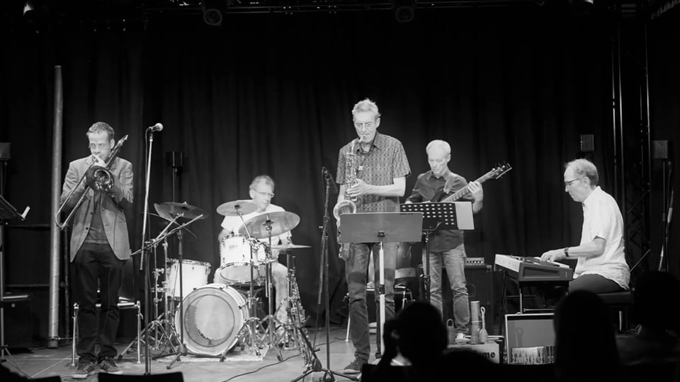 Ein schwarz-weiss Foto der Band live auf der Bühne 