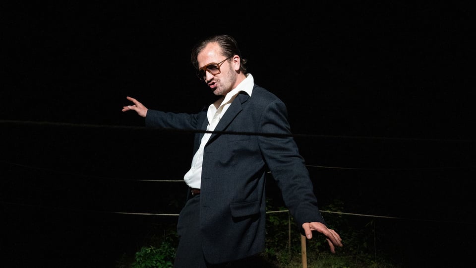 Der Künstler tanzend in einem schwarzen Anzug