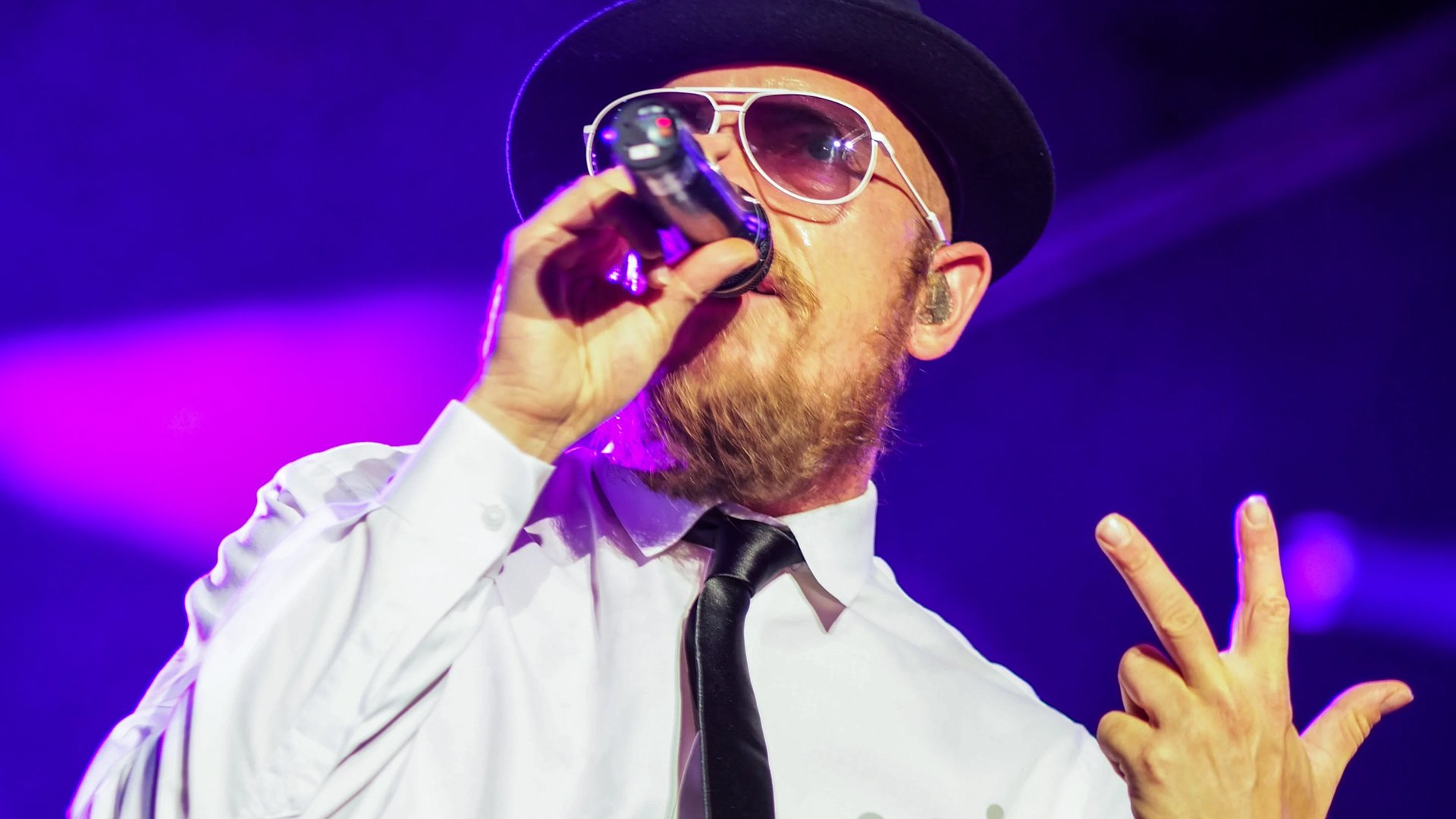 Jan Delay gibt ein Konzert und singt in ein Mikrofon