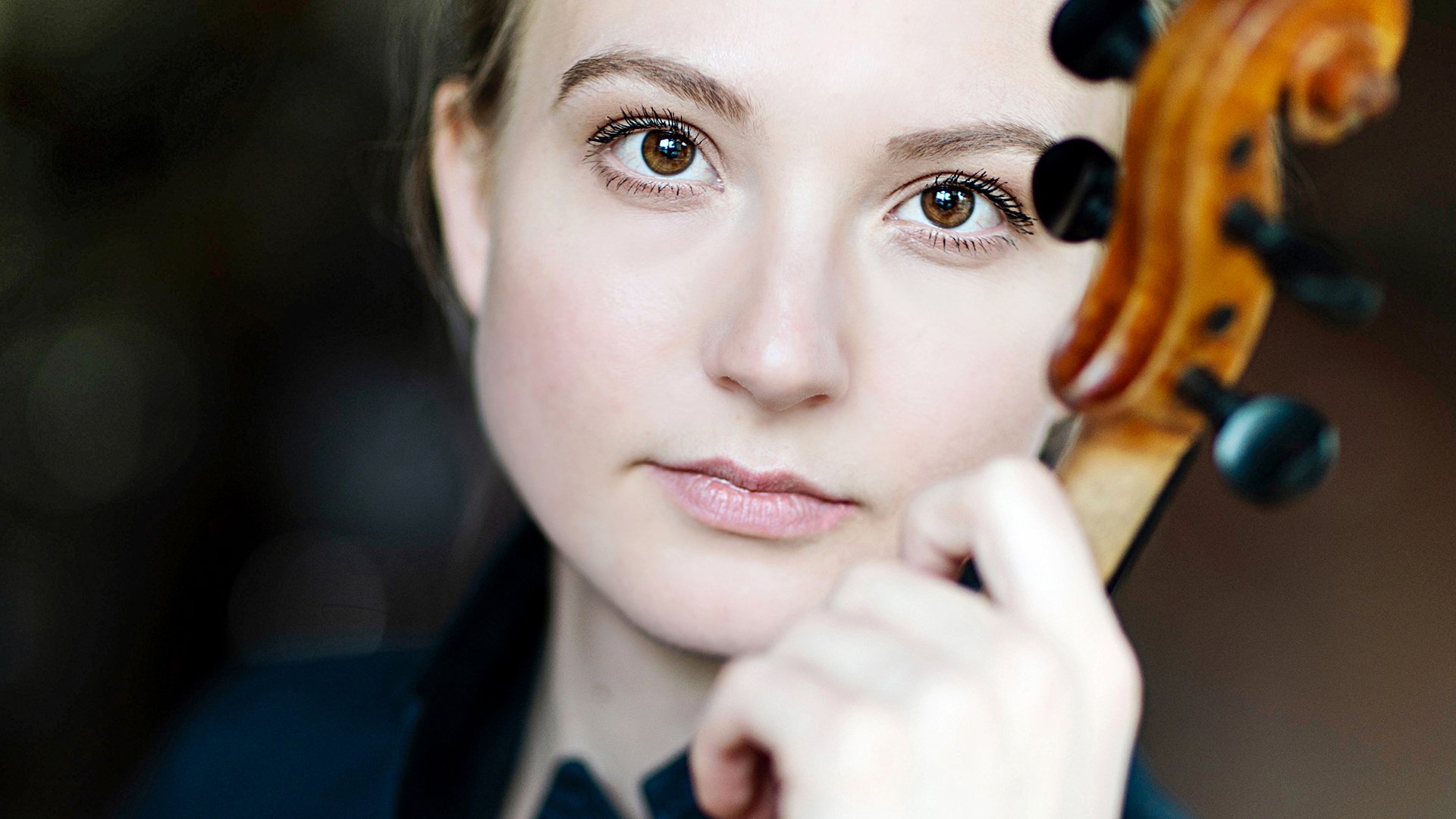 Frühlingskonzert: Solistin mit Violine in Nahaufnahme, hält das Instrument am Kinn; Porträt einer Geigerin mit dunkler Kleidung vor unscharfem Hintergrund.