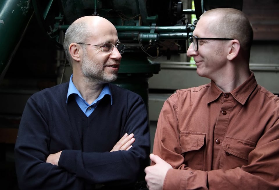 Gunkl & Harald Lesch stehen nebeneinander uns sehen sich an und lächeln sich zu