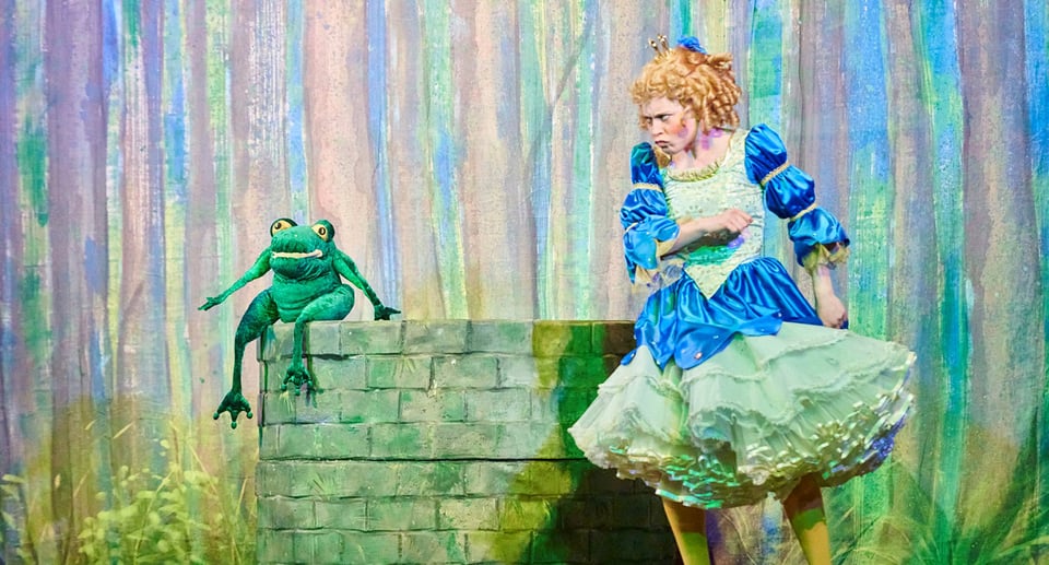 Zeichnung von einer Prinzessin und einem Frosch an einem Brunnen sitzend