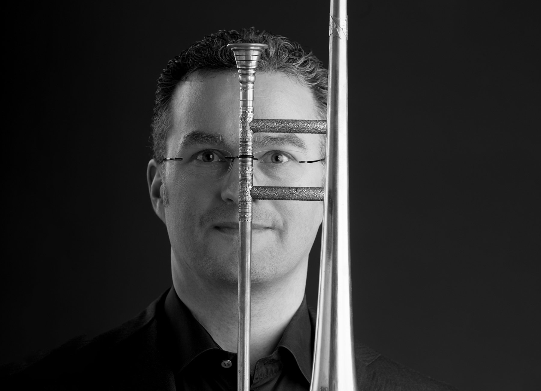 Foto des Gesichts eines Mannes mit einem Instrument vor seinem Gesicht. Das Foto ist in schwarz-weiß
