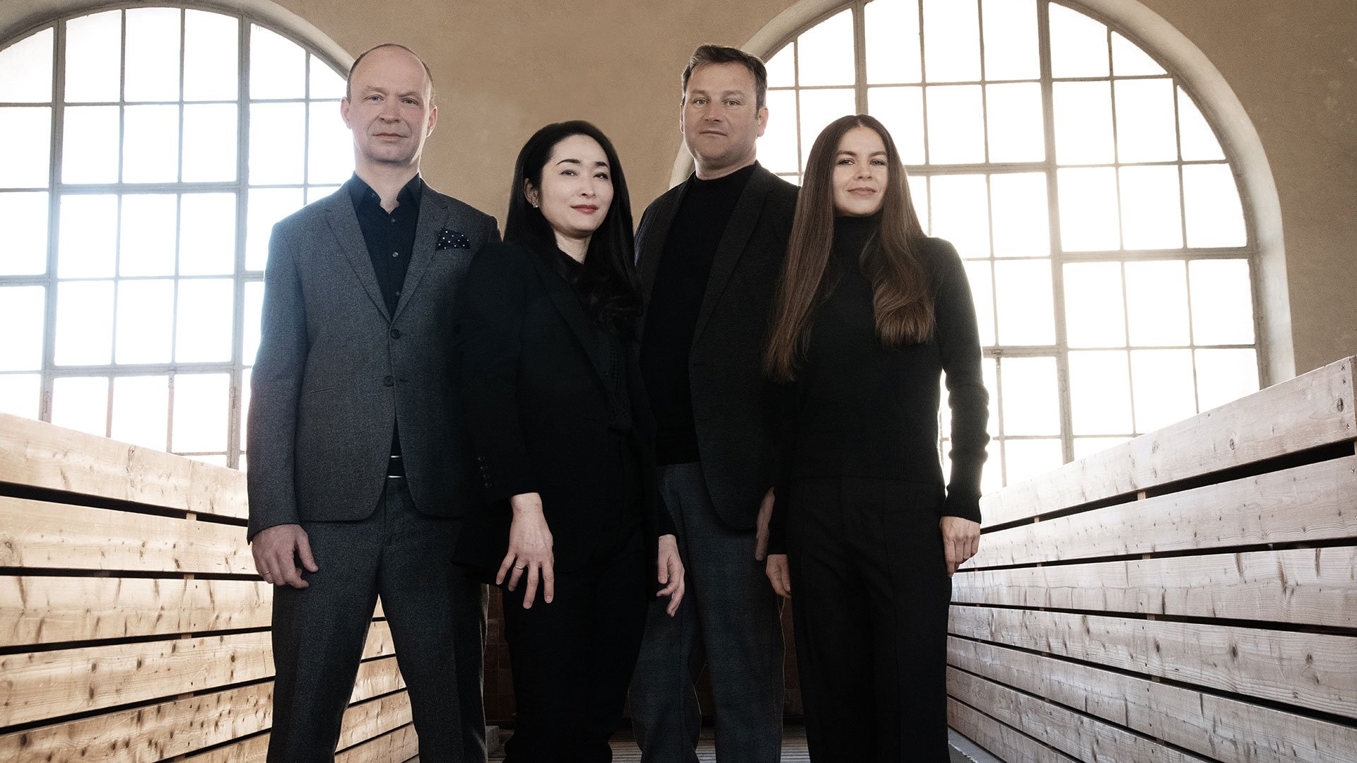 Veranstaltungsfoto zum Konzert mit dem Leopold Mozart Quartett: Das Ensemble vor zwei großen Fensterfronten aus Glas
