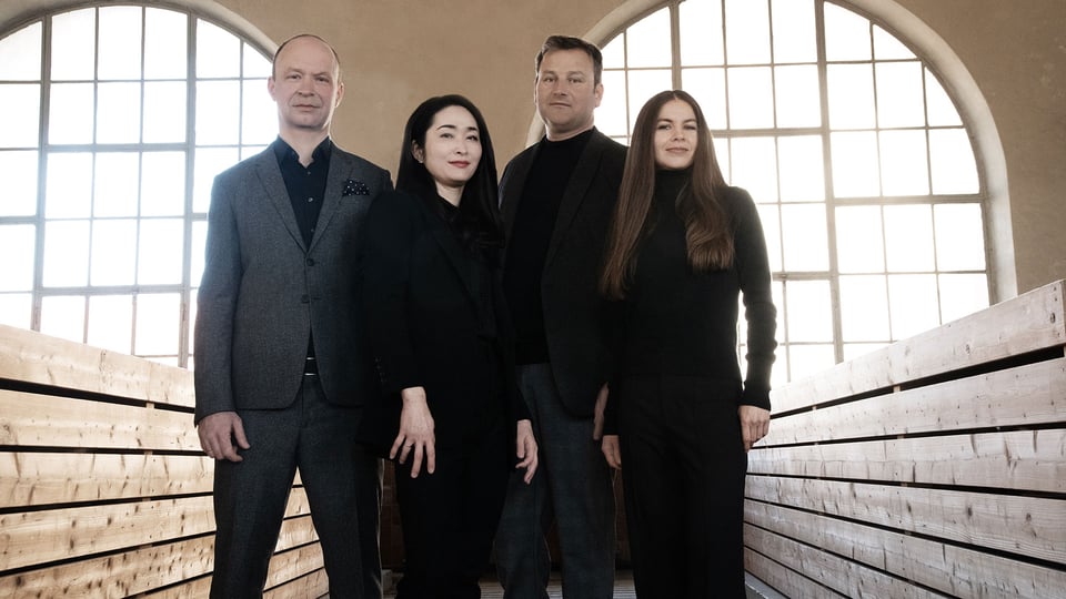 Veranstaltungsfoto zum Konzert mit dem Leopold Mozart Quartett: Das Ensemble vor zwei großen Fensterfronten aus Glas