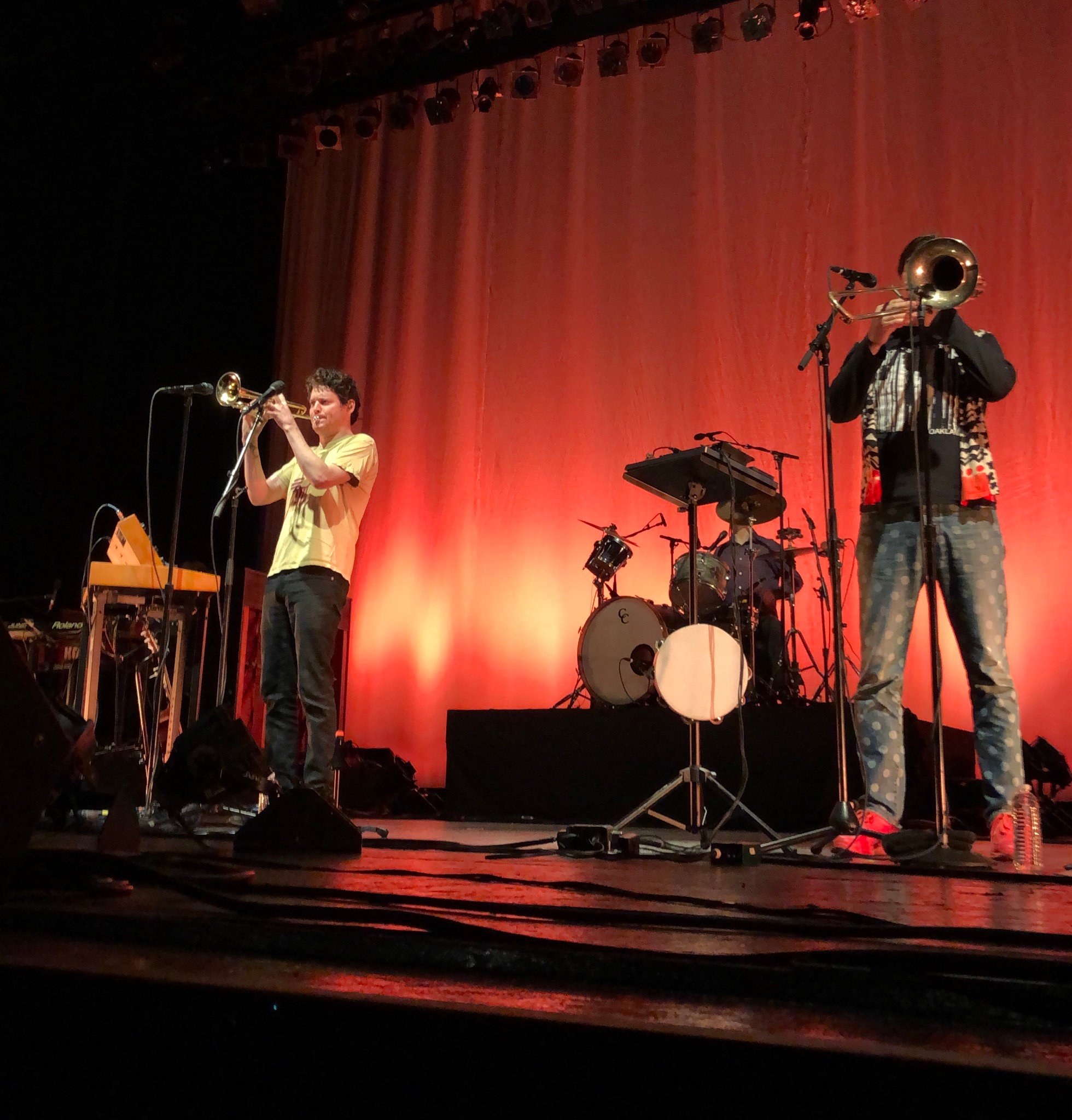 die Band Beirut auf einer Bühne in rotem Scheinwerferlicht