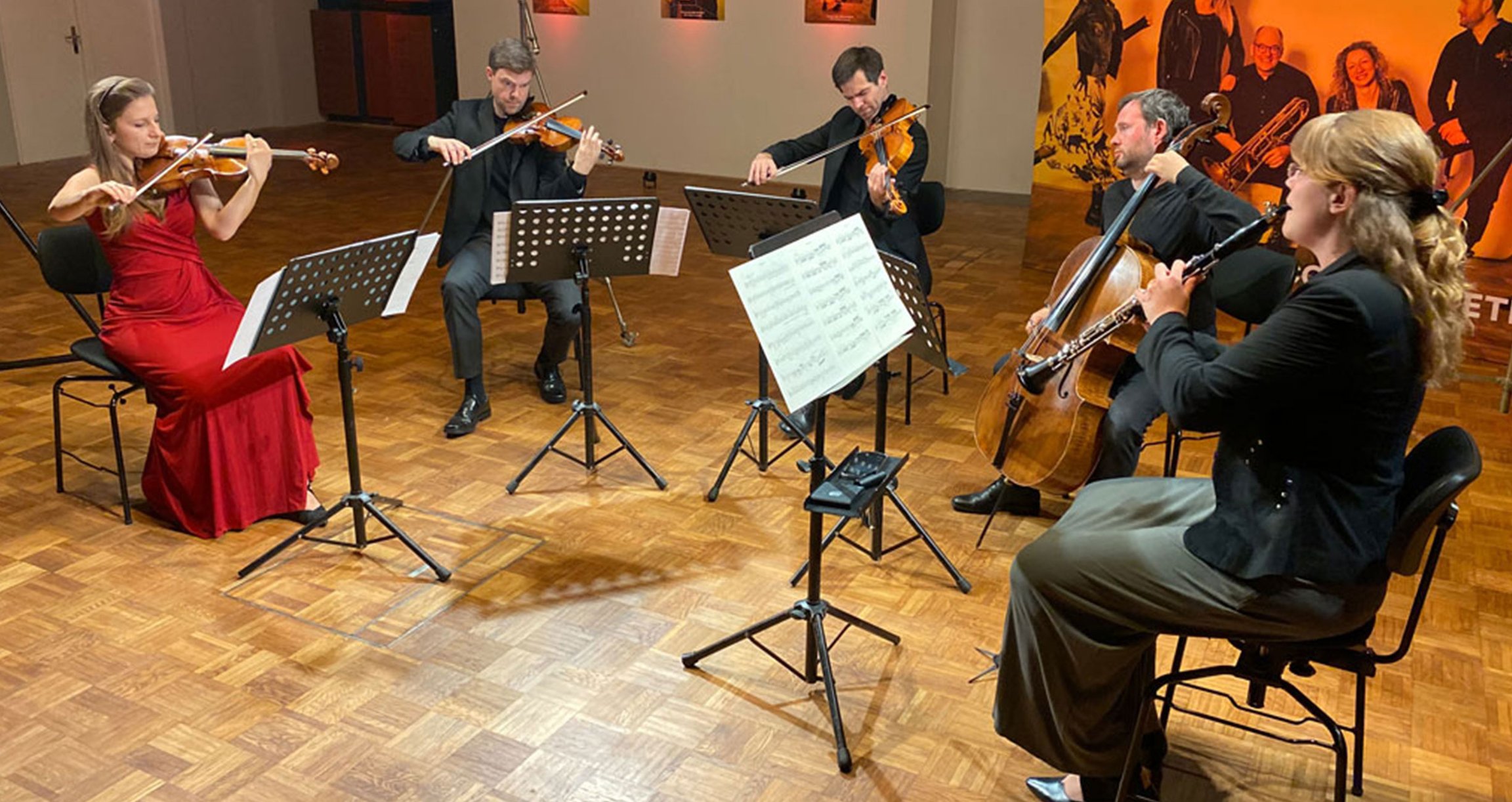 Fünf Musikerinnen und Musiker mit Instrumenten, live bei einem Konzertauftritt