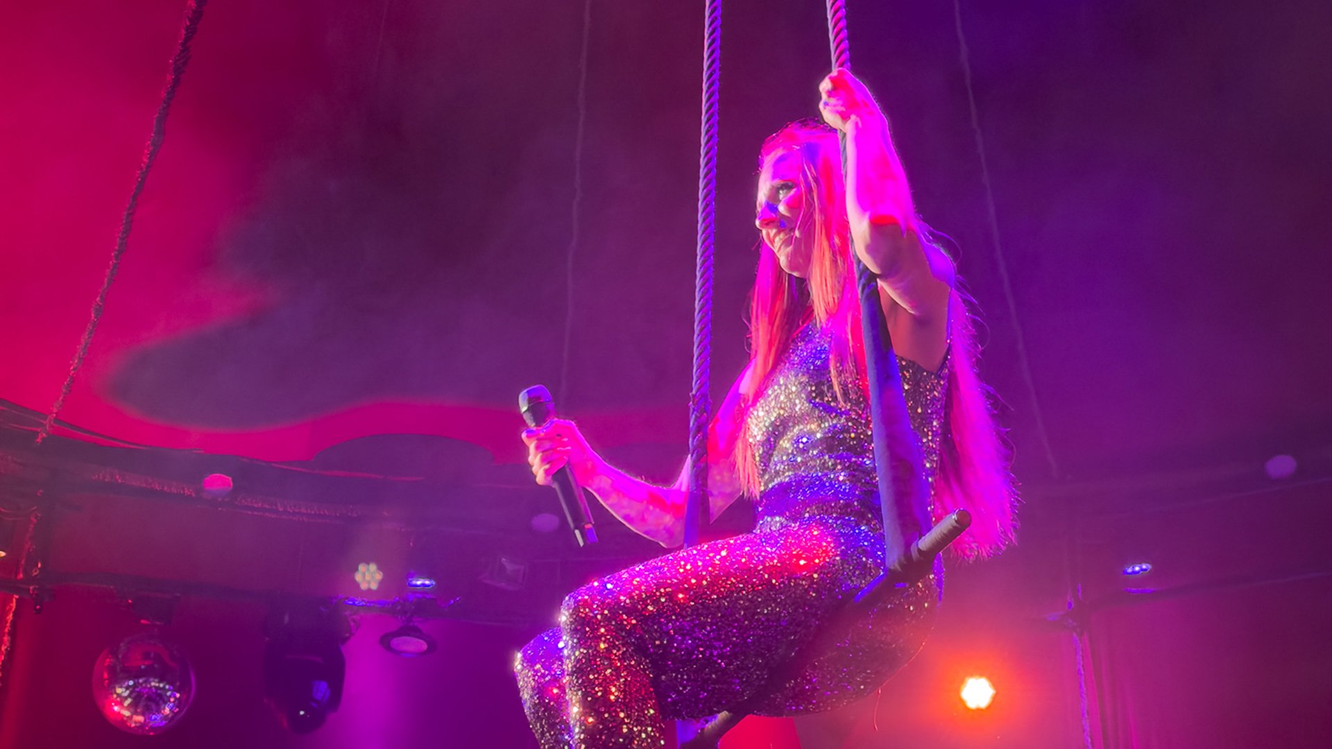 EIne Artistin mit Mikrofon im Scheinwerferlicht