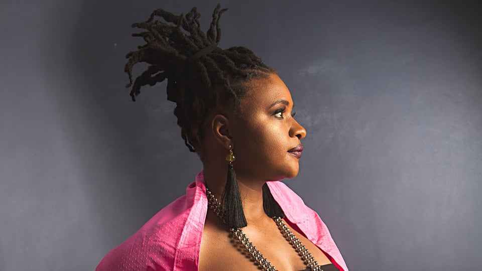 Foto der Sängerin im Profil in pinker Kleidung 