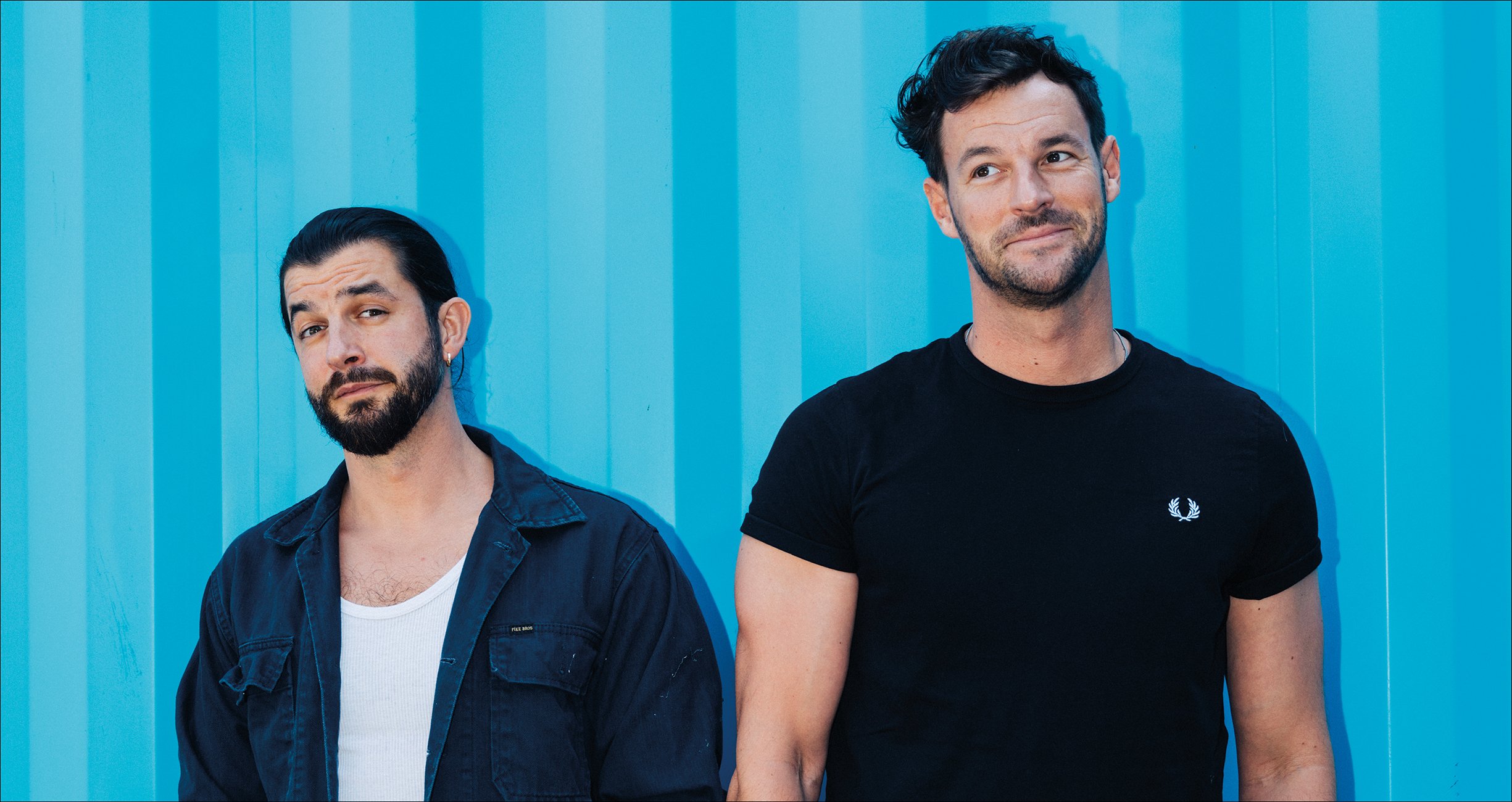 die beiden Künstler auf blauem Hintergrund