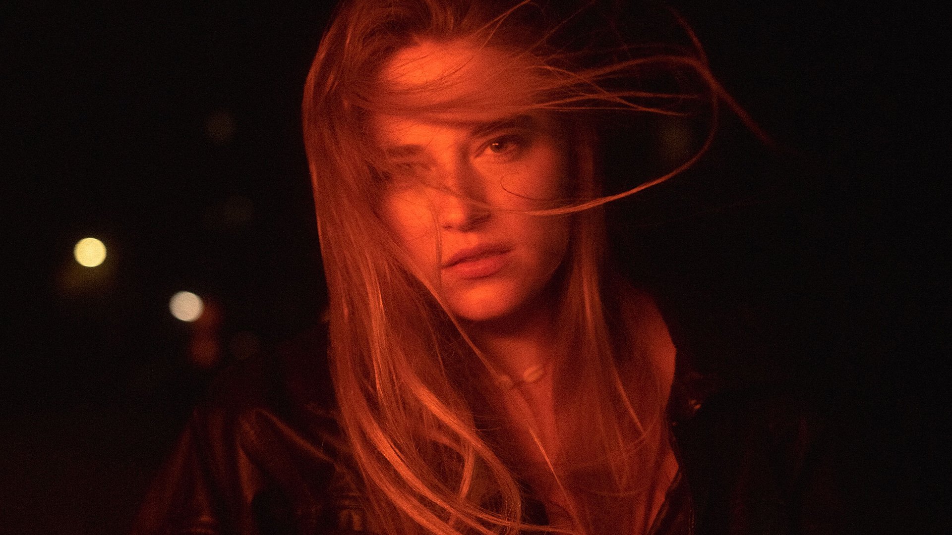 Foto für das Konzert von GRETA – SONNE UND SCHMERZ TOUR, mit einem Bild der Künstlerin, in dem ihr Gesicht von orangem Licht beleuchtet wird, vor schwarzem Hintergrund