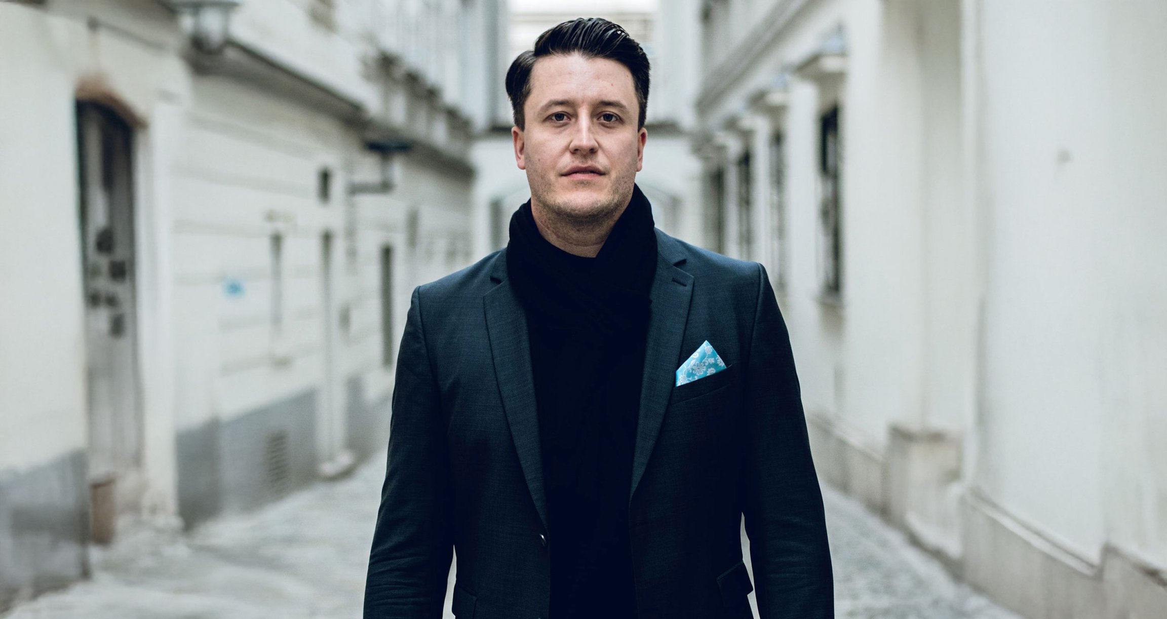 Ein Mann mit Sakko steht vor einer Straße