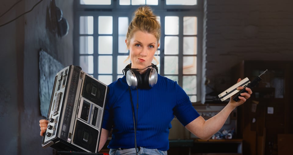 eine Frau mit einem antiken Radio in der Hand und einem Fenster im Hintergrund