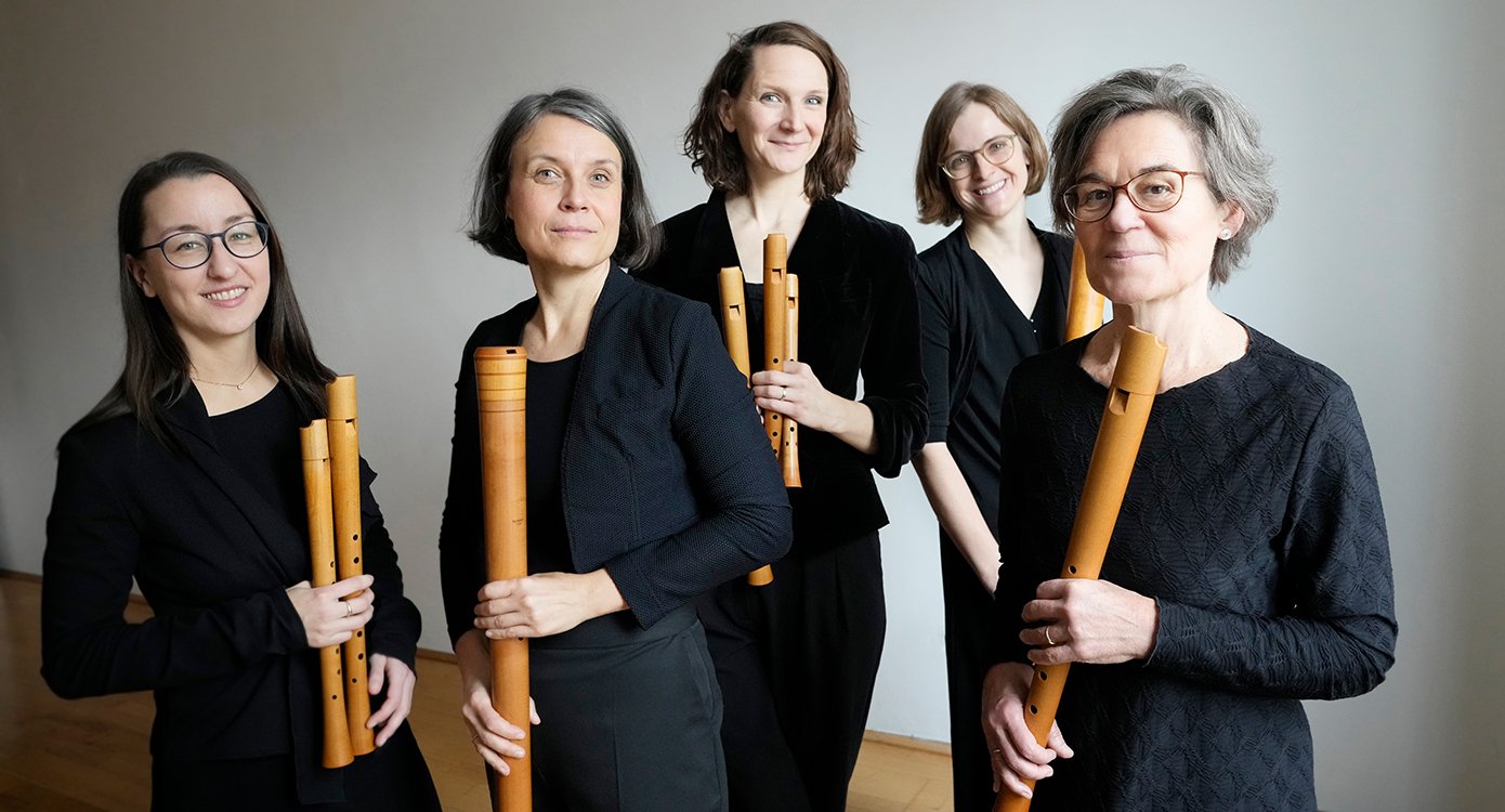 fünf Frauen mit Instrumenten, schwarz gekleidet, auf weißem Hintergrund