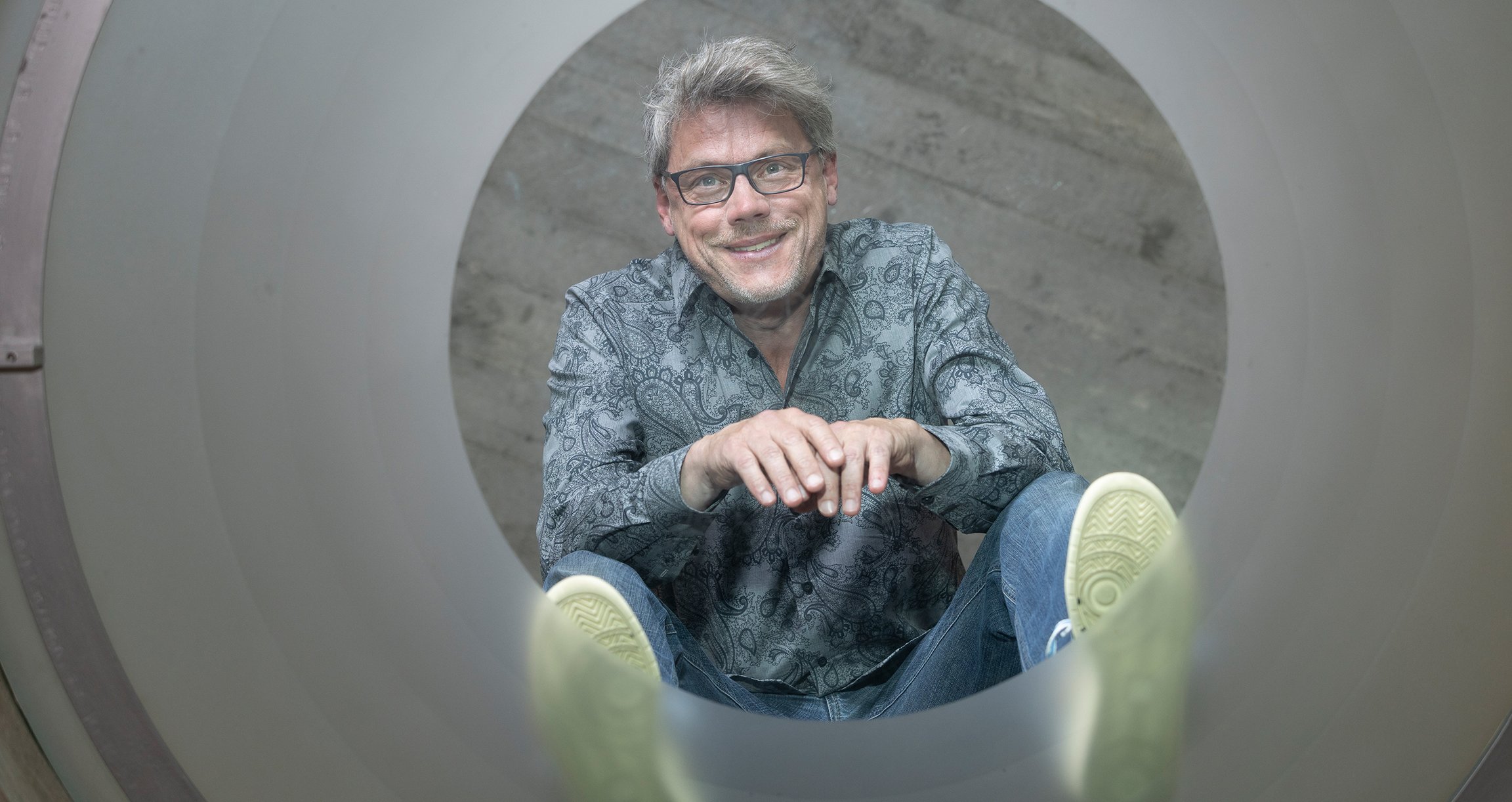 Foto des Künstlers, das sich in einem Spiegel auf dem Boden spiegelt