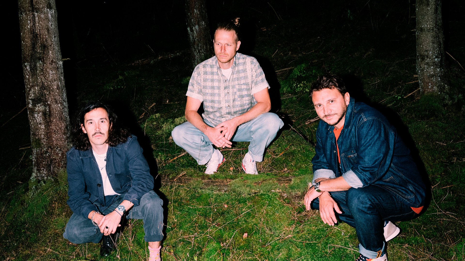 Drei Personen bei Nacht in einem Wald