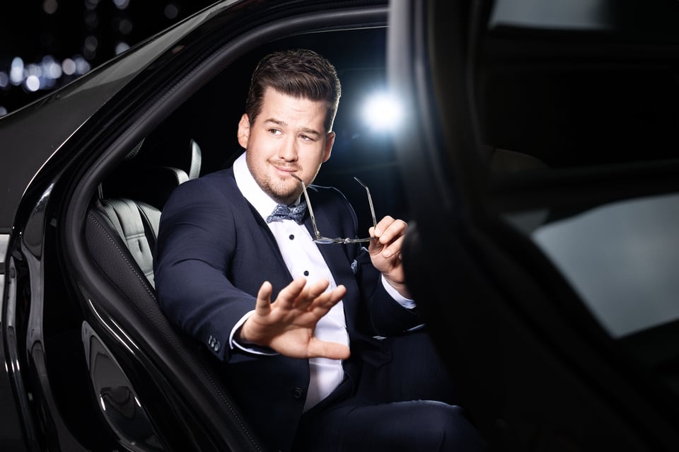 Person steigt aus Auto mit Sonnenbrille in der Hand