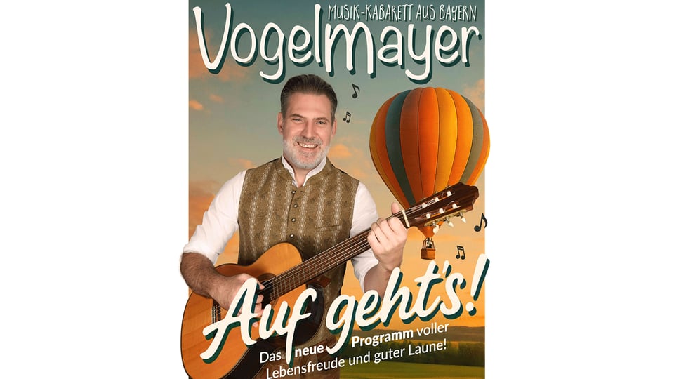 Plakat mit Person und Akustikgitarre vor Heissluftballon sowie den Aufschriften Musik Kabarett aus Bayern Vogelmayer und Auf gehts Das neue Programm voller Lebensfreude und guter Laune