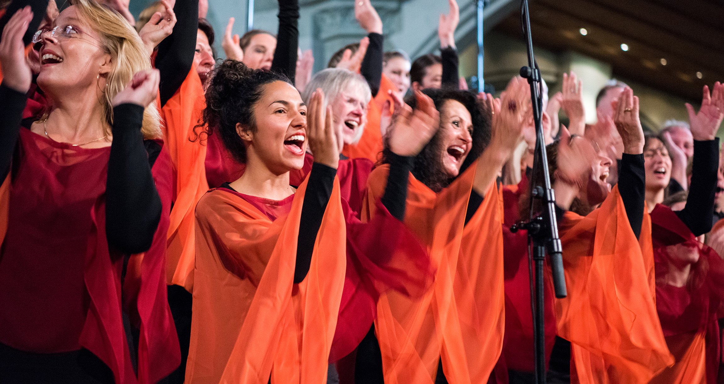 Foto des Chors nur mit Frauen, gekleidet in Orange