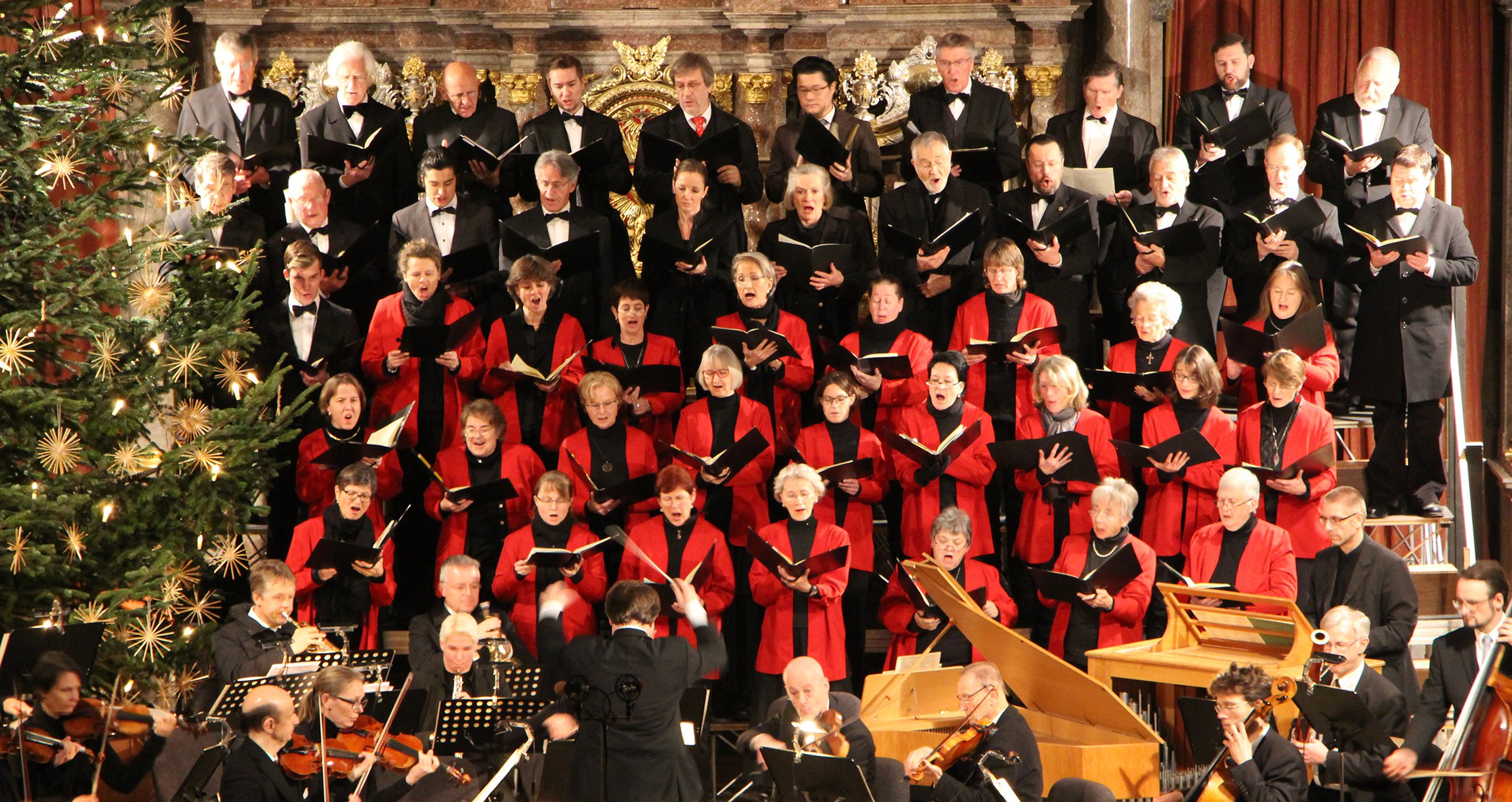Foto des Chors und des Orchesters mit einem Weihnachtsbaum