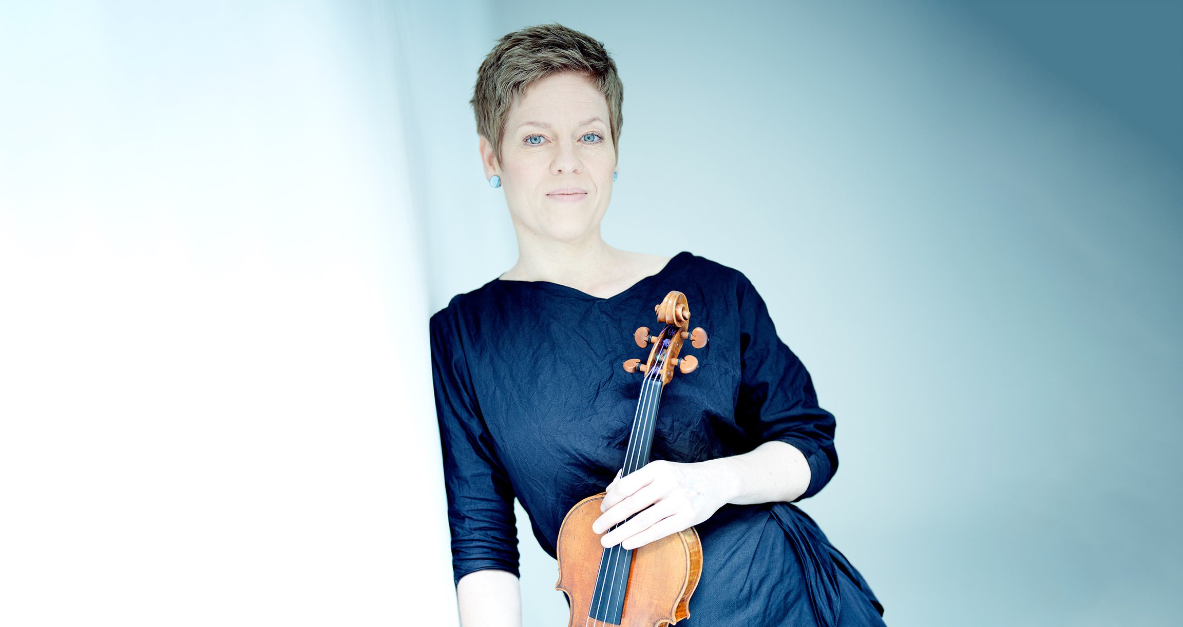 Foto einer Dame mit einem Instrument in der Hand, auf blauem Hintergrund