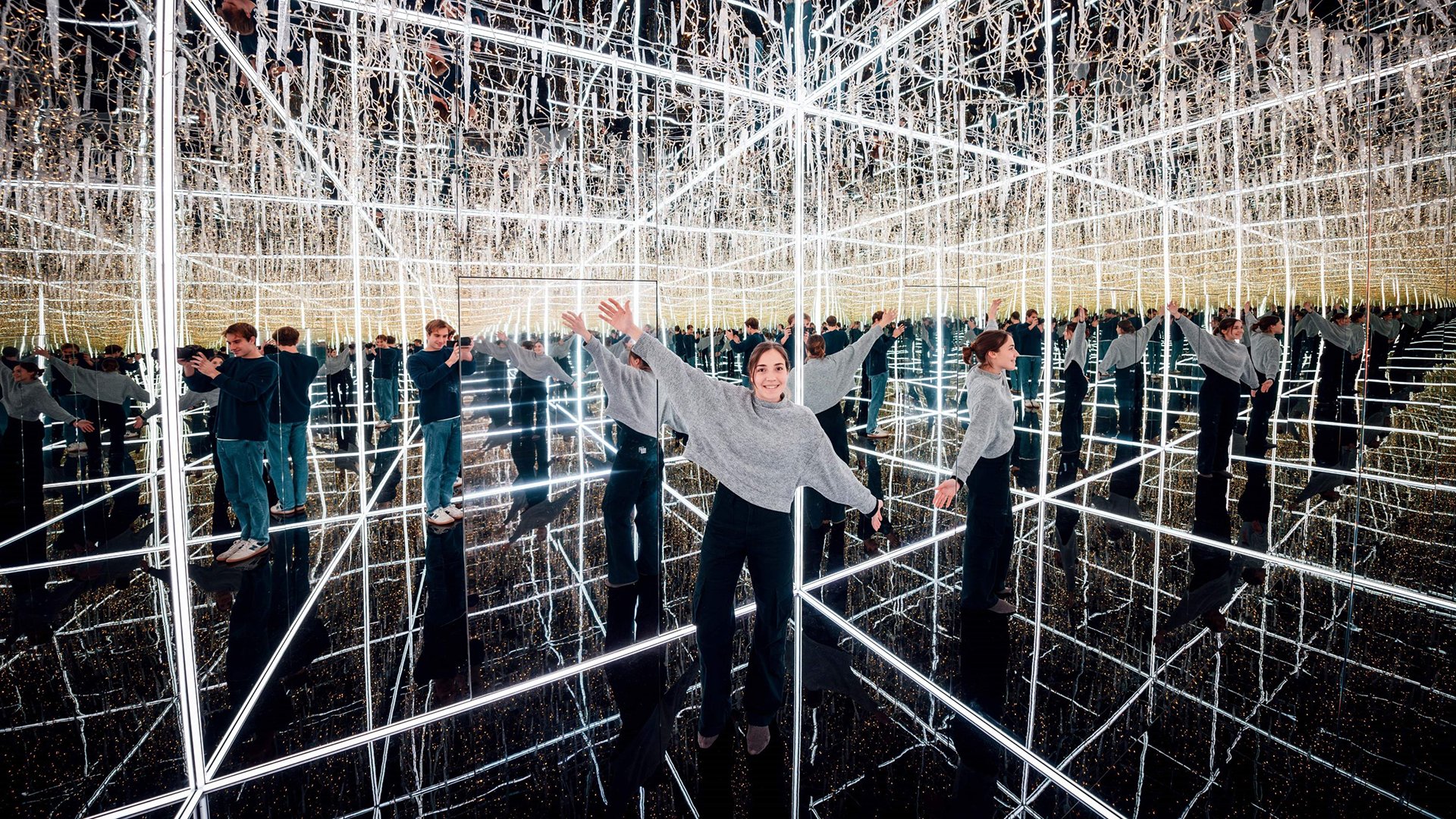 Zwei Personen mit zahlreichen Spiegelbildern in einem Infinity Room