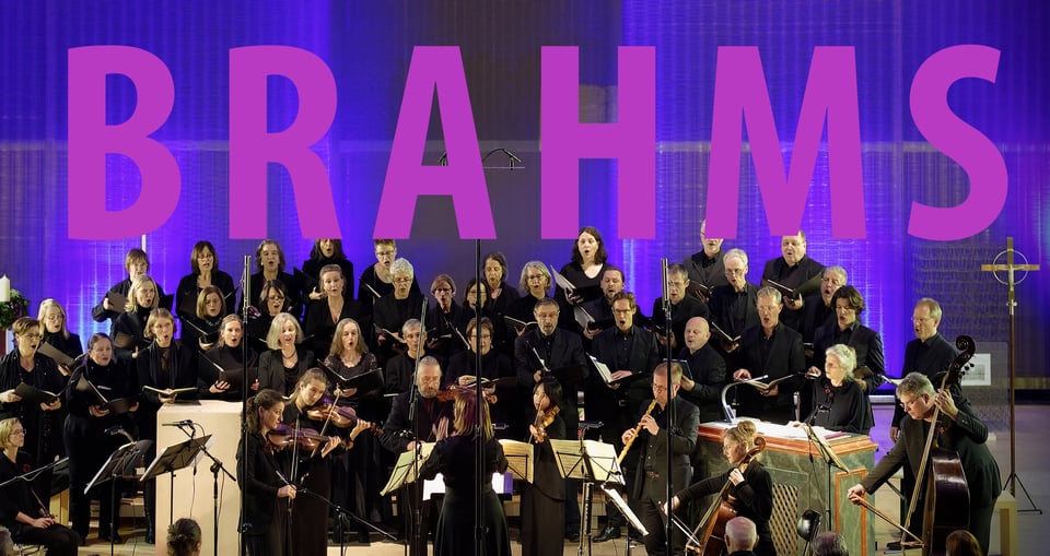 Chor mit Instrumenten vor blauem Hintergrund und rosa Schrift – offizielles Veranstaltungsbild zu „J. Brahms | Ein Deutsches Requiem“.