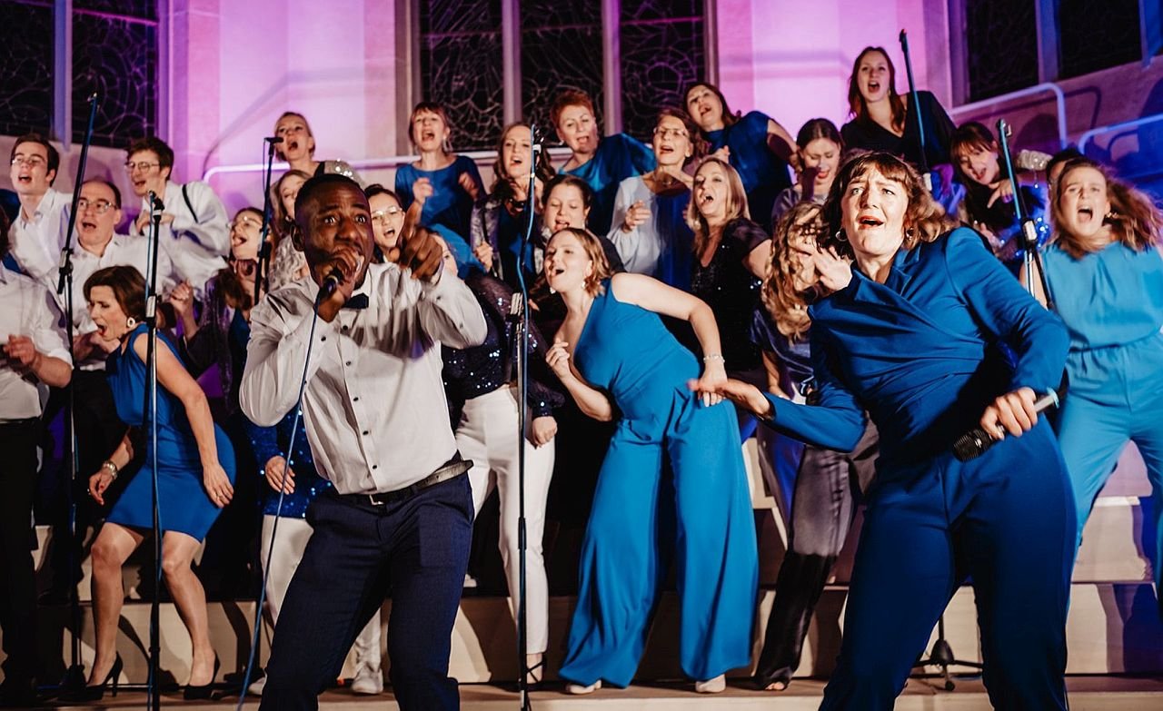 Ein Foto für die Veranstaltung Gospel’n’Soul mit allen Künstlerinnen in Blau und den Männern in weißen Hemden