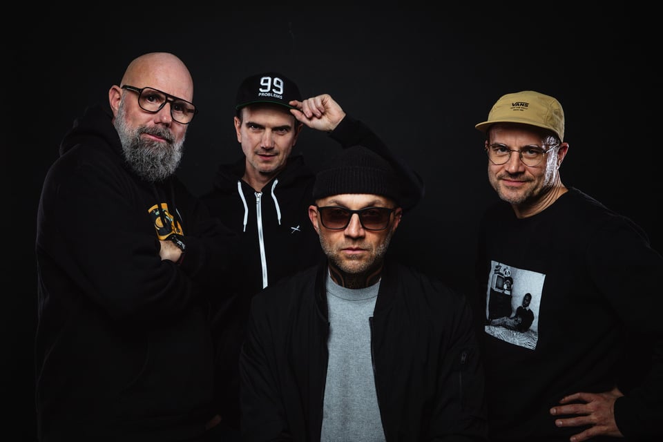 Vier Männer in dunkler Kleidung vorschwarzem Hintergrund